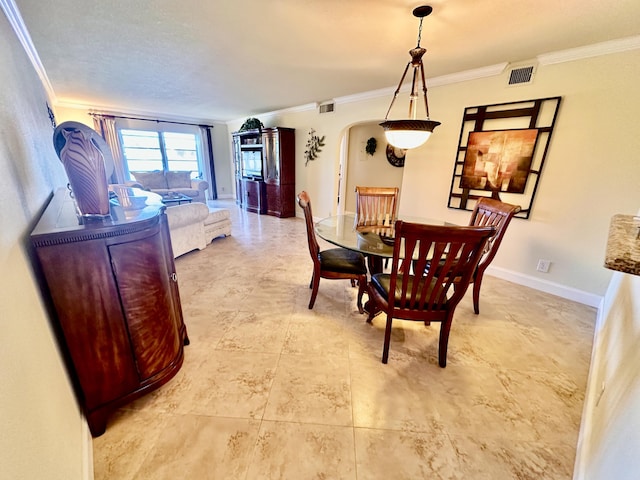 dining room featuring arched walkways, visible vents, and crown molding