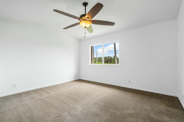 carpeted spare room with ceiling fan and vaulted ceiling