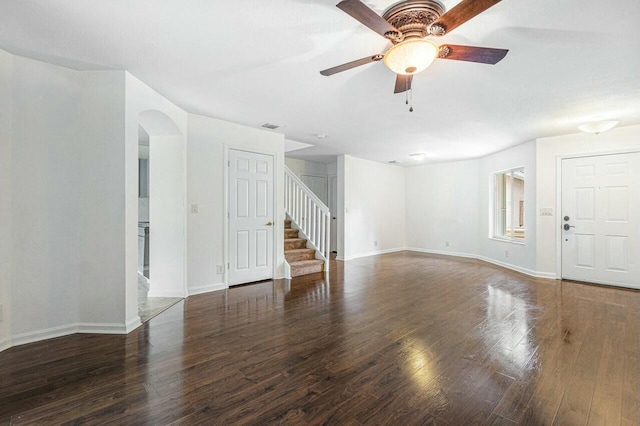 unfurnished living room with ceiling fan and dark wood-type flooring