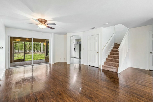 unfurnished living room featuring ceiling fan and dark wood-type flooring