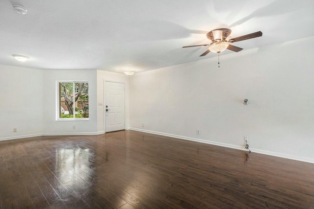 spare room featuring dark wood-type flooring and ceiling fan