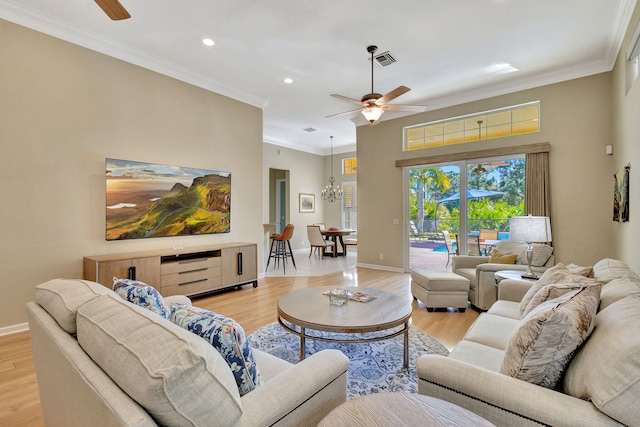 living room featuring baseboards, light wood finished floors, ornamental molding, and visible vents