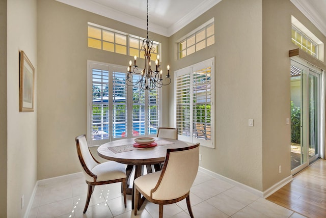 dining room featuring ornamental molding, baseboards, plenty of natural light, and a chandelier