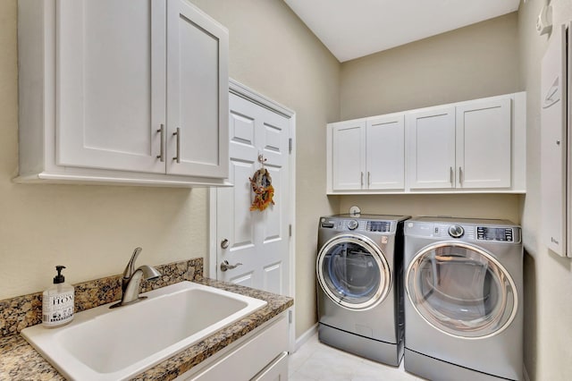 laundry room with baseboards, washing machine and dryer, a sink, light tile patterned floors, and cabinet space