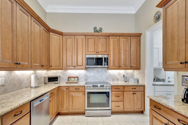 kitchen featuring tasteful backsplash, appliances with stainless steel finishes, light stone countertops, and crown molding