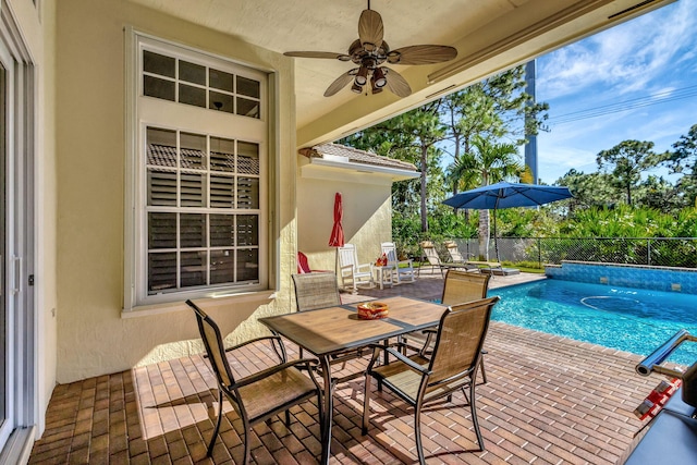 view of patio with fence, outdoor dining space, ceiling fan, and a fenced in pool