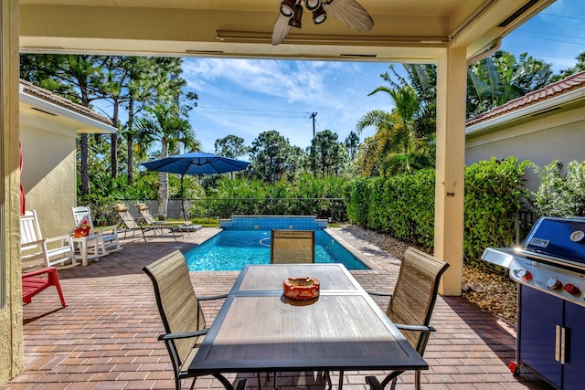 view of swimming pool featuring a grill, fence, outdoor dining space, ceiling fan, and a fenced in pool