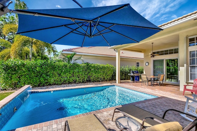 view of swimming pool with a fenced in pool, ceiling fan, a patio, and area for grilling