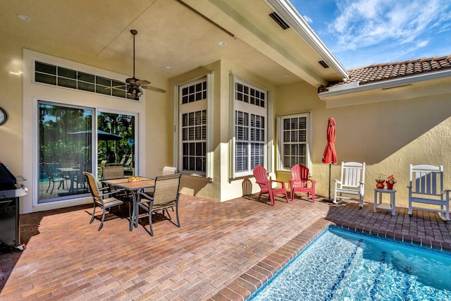 view of patio / terrace with outdoor dining space, ceiling fan, and an outdoor pool