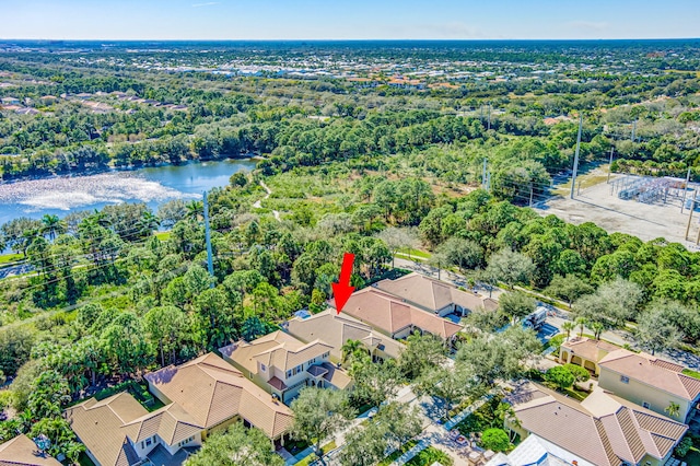 drone / aerial view featuring a forest view, a residential view, and a water view