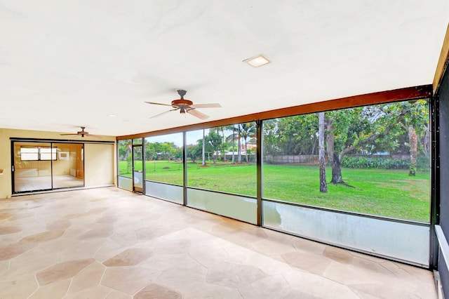 unfurnished sunroom featuring ceiling fan