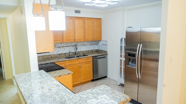 kitchen with visible vents, hanging light fixtures, backsplash, appliances with stainless steel finishes, and a sink