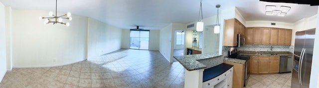 kitchen with a peninsula, appliances with stainless steel finishes, dark countertops, and pendant lighting