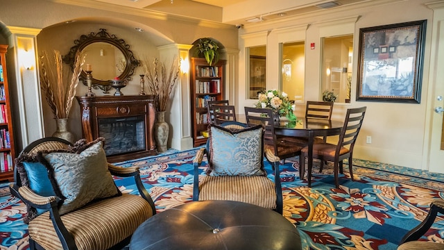 sitting room with a fireplace with raised hearth and crown molding