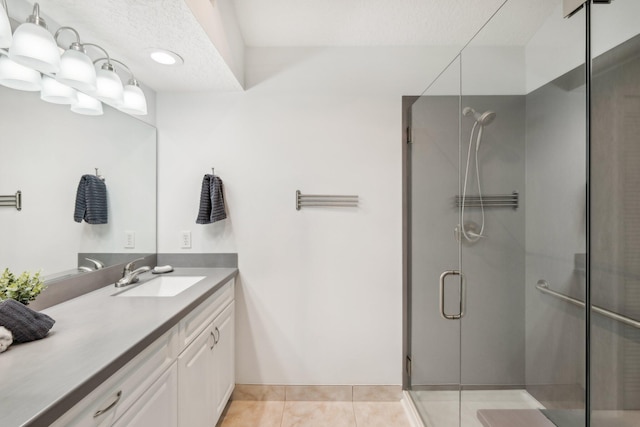 bathroom featuring a stall shower, tile patterned flooring, and vanity