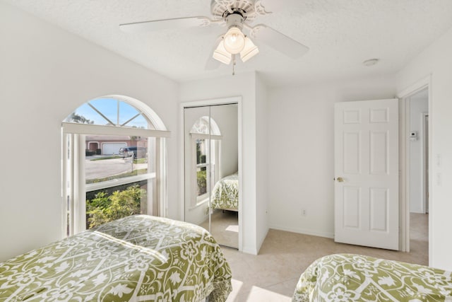 bedroom with a closet, ceiling fan, and a textured ceiling