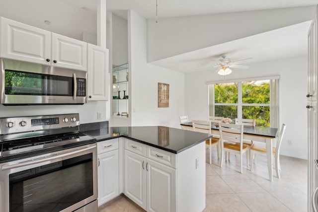 kitchen featuring a peninsula, white cabinetry, appliances with stainless steel finishes, and light tile patterned flooring