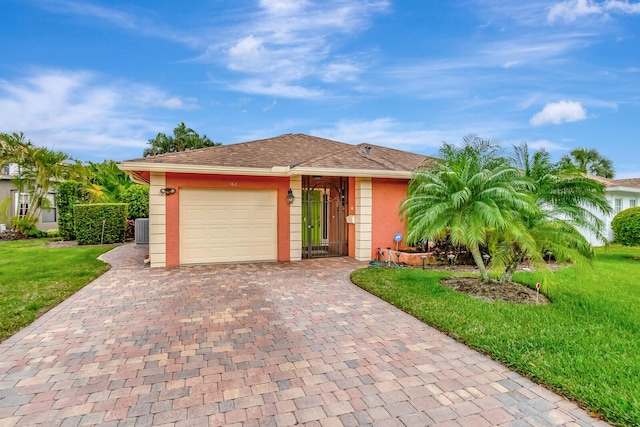 single story home featuring decorative driveway, stucco siding, central AC, a garage, and a front lawn