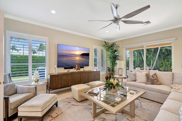 living area featuring a healthy amount of sunlight, visible vents, and crown molding