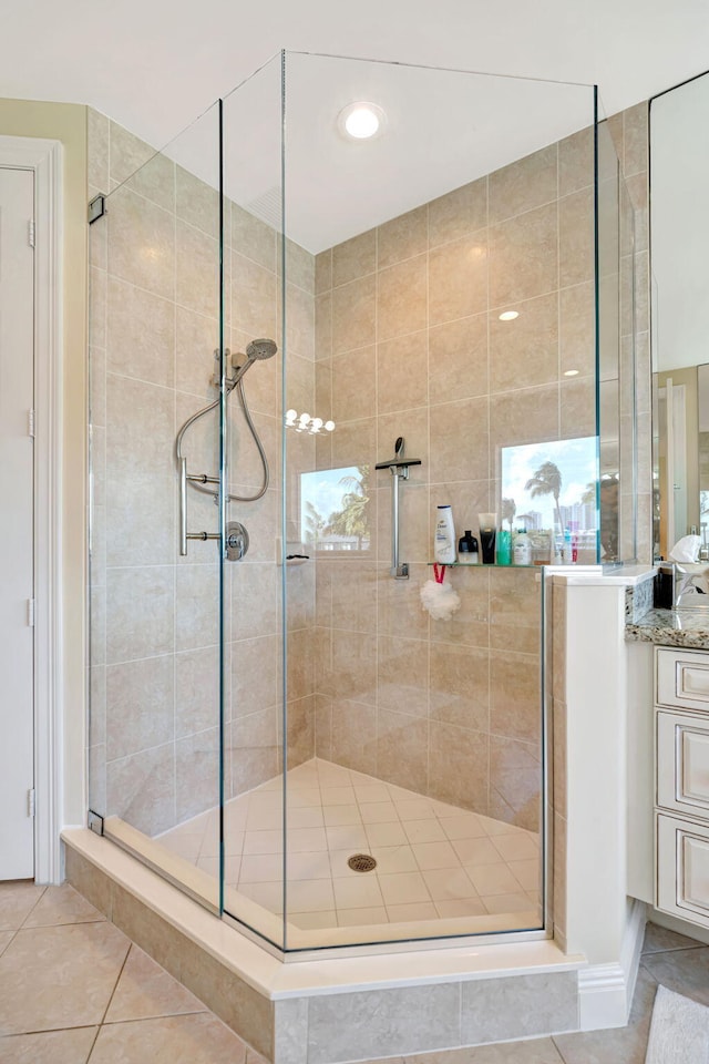 full bathroom with a shower stall, vanity, and tile patterned floors