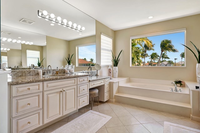 bathroom featuring a garden tub, tile patterned flooring, vanity, and a healthy amount of sunlight