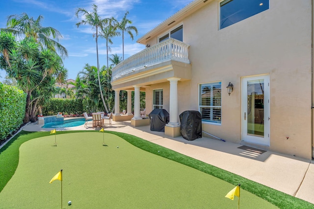 exterior space with a fenced in pool, a patio, a balcony, and stucco siding