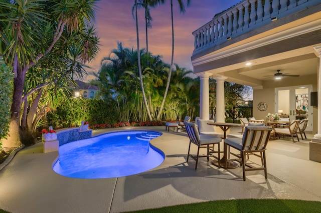 pool at dusk with a fenced in pool, a patio, an outdoor hangout area, a ceiling fan, and outdoor dining space