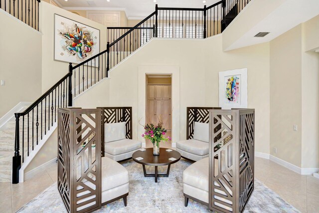 entryway with decorative columns, arched walkways, baseboards, ornamental molding, and tile patterned flooring