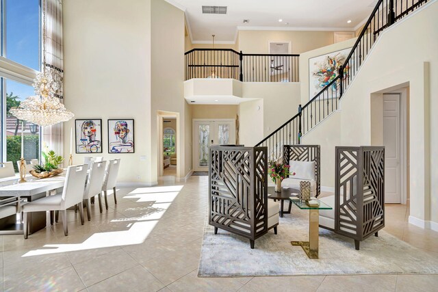 dining space with a towering ceiling, an inviting chandelier, baseboards, and tile patterned floors