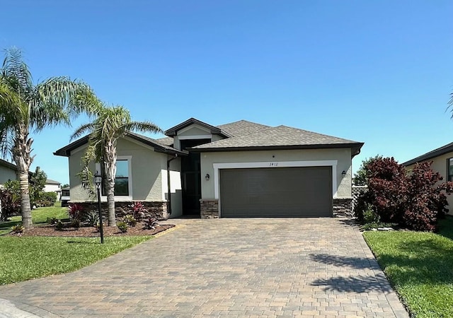 view of front facade with stucco siding, decorative driveway, stone siding, a front yard, and an attached garage