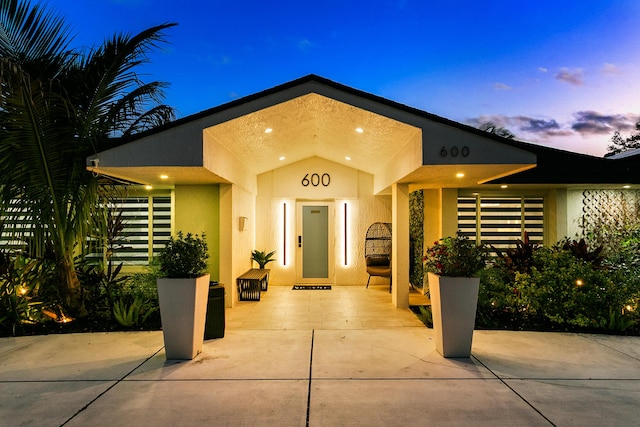 property entrance featuring elevator and stucco siding