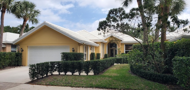 single story home featuring a garage, concrete driveway, and stucco siding