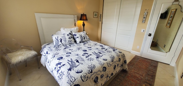 tiled bedroom with a closet and baseboards