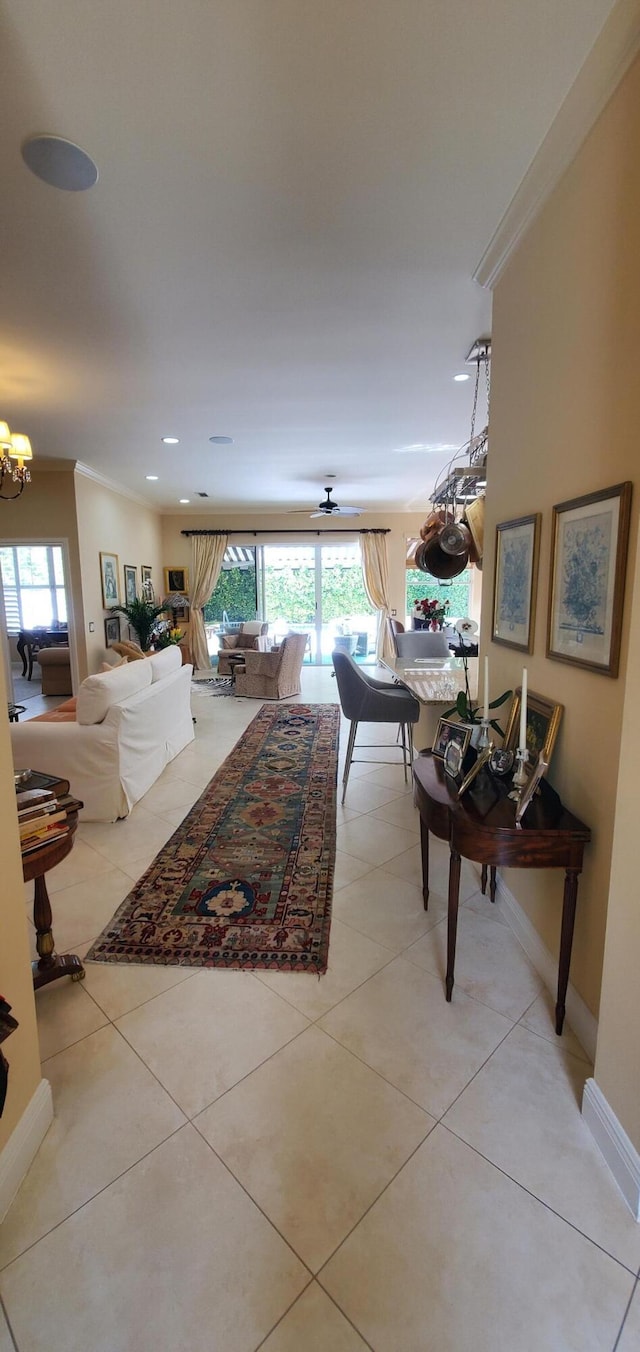 living room featuring a notable chandelier, ornamental molding, and a healthy amount of sunlight