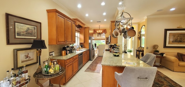 kitchen featuring light stone counters, hanging light fixtures, an inviting chandelier, stainless steel appliances, and crown molding