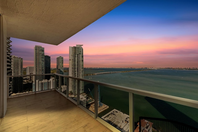 balcony at dusk featuring a view of city