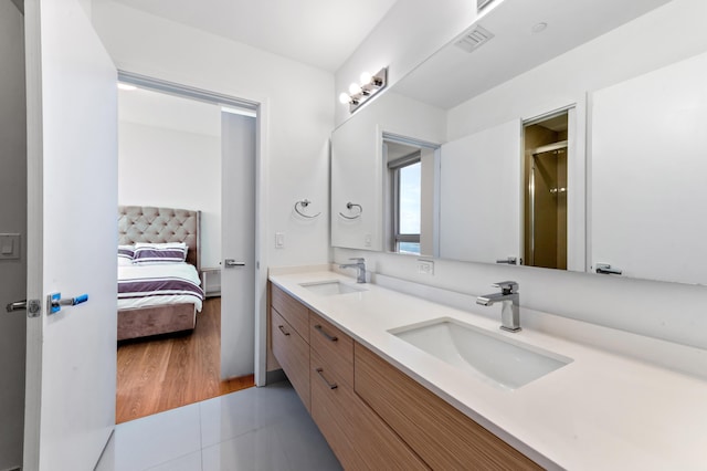 ensuite bathroom featuring double vanity, visible vents, a sink, and ensuite bathroom