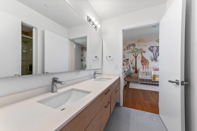 full bathroom with double vanity, ensuite bath, a sink, and wood finished floors