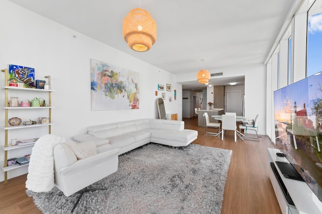 living area with visible vents and wood finished floors