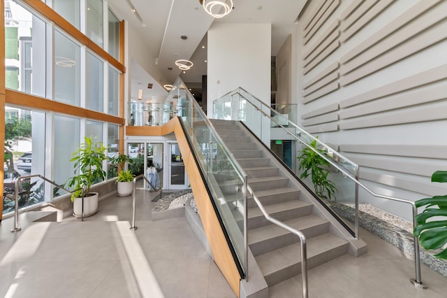 stairway featuring a towering ceiling