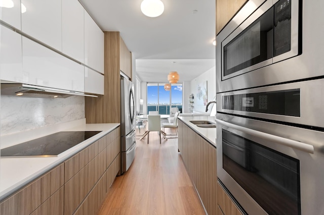 kitchen featuring appliances with stainless steel finishes, light countertops, white cabinets, and modern cabinets