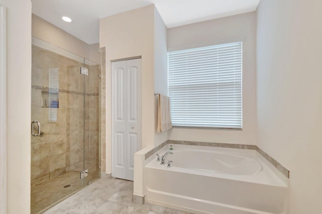 bathroom featuring a closet, a stall shower, and a garden tub