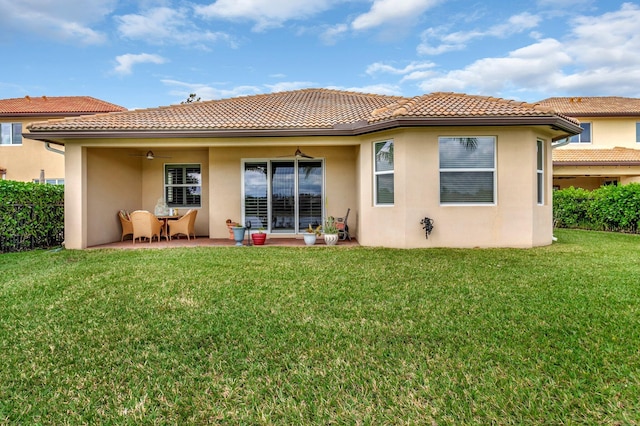 back of property featuring a tile roof, a lawn, a patio area, fence, and ceiling fan