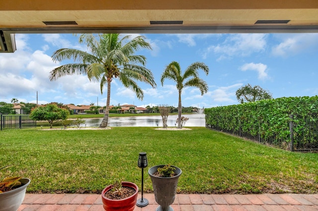 view of yard with a water view and fence