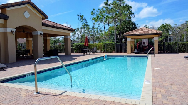 pool with a patio area, fence, a gazebo, and ceiling fan