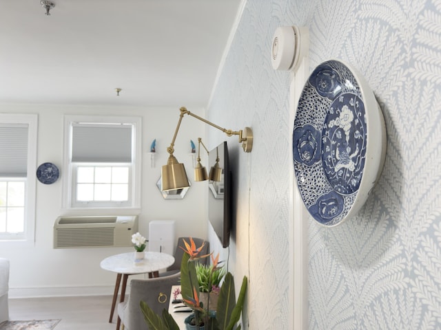 interior space featuring baseboards, wood finished floors, and a wall mounted AC