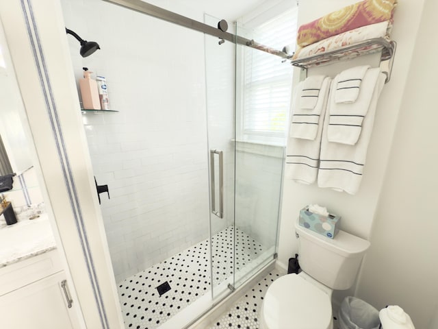 full bath with a stall shower, vanity, and toilet