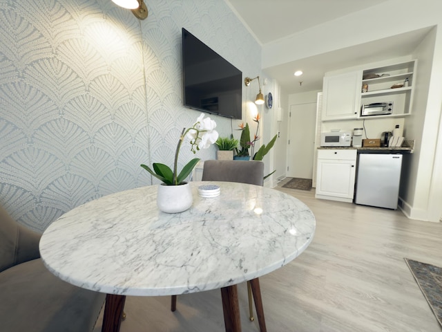 dining area featuring recessed lighting, an accent wall, light wood-style floors, baseboards, and wallpapered walls