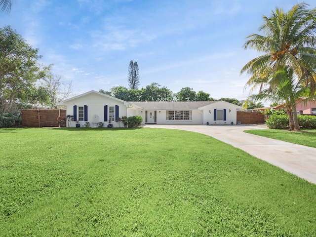 ranch-style house featuring fence, a front lawn, and concrete driveway