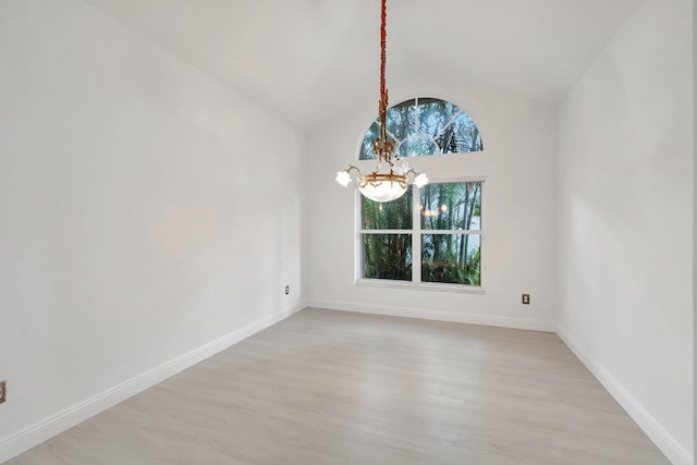 unfurnished room featuring vaulted ceiling, light wood finished floors, an inviting chandelier, and baseboards